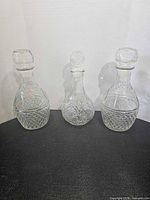 Front view of three clear glass decanters showing overall shapes and patterns