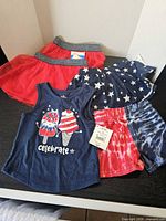 All four baby clothing items displayed: tank top, two skirts, shorts