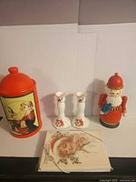 Full lot showing cookie jar, two candlesticks, nesting Santa doll, vintage cards