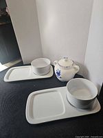 Two white soup/sandwich plate sets and blue floral garlic keeper displayed