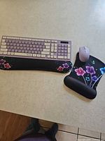 Full set showing lavender keyboard, lavender mouse, floral keyboard wrist rest and mouse pad