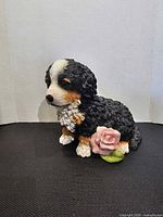 Front view of Stone Critters resin puppy coin bank showing detailing and rose accent