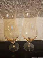 Both amber hurricane vases front view