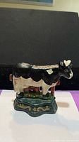 Front view of painted cast iron cow doorstop showing colours and form