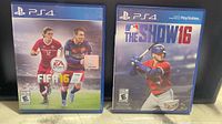 Front view of both PS4 game cases: FIFA 16 and MLB The Show 16