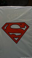 Front of sealed polybag showing red Superman shield on white background