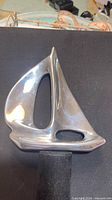Front view of polished aluminum sailboat sculpture