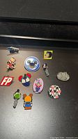 All eleven Disney trading pins laid out on black surface