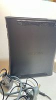 Left rear side of Xbox 360 console with AV cable visible