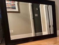 Front view of large Pier 1 mirror leaning horizontally against wall