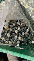 Close view into bag showing many hex-head screws with beige washers
