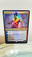Front of oversized foil Saheeli card showing artwork and text