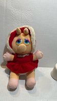 Front view of Miss Piggy plush doll in red outfit
