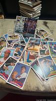 Fronts of assorted baseball cards spread on table with stacked pile