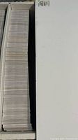 Top view of full row of stacked trading cards in box