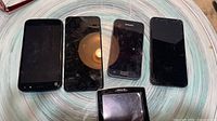 Front view of five smartphones and Magellan GPS