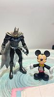 Front view of both Batman and Mickey Mouse figurines