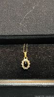 Pendant and portion of chain against dark background