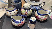 All seven items grouped: gravy boat, three creamers, large salt container, small shaker, mug