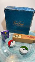 Overall lot showing Trivial Pursuit box, domino set, Spyro case, two Poké Ball containers
