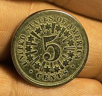 Reverse view showing numeral 5, stars and rays