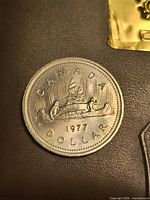 Reverse of 1977 Canadian dollar showing voyageurs in canoe and date