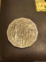 Reverse of the Australian 50 cent coin showing coat of arms with kangaroo and emu