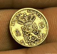 Obverse view of coin held between fingers showing legend, coat of arms, denomination and date