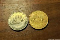 Both 1969 Canadian dollar coins reverse side on wood surface