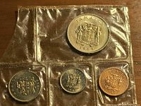 Obverse view showing coat of arms on all four coins in sealed pack