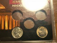 front of plastic display with two coins in lower positions