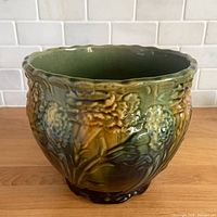 Front view of glazed majolica jardiniere showing floral relief and overall condition