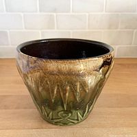 Front view of stoneware planter showing glaze and relief design