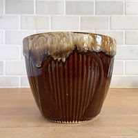Front view showing brown body, cream drip rim, ribbed Gothic panel