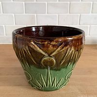 Front view showing raised sun motif, green and brown glaze