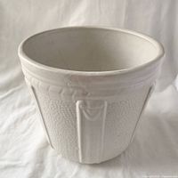 Front angled view of jardiniere showing strap relief and texture