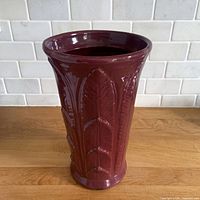 front view of plum stoneware vase with palm leaf relief
