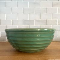 Side view of dark green ribbed beehive mixing bowl