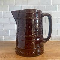 Front view of brown stoneware pitcher showing pattern and form