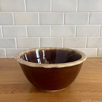 Side angled view of entire bowl showing brown glaze and drip rim