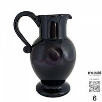 Front view of dark amethyst purple hand blown glass pitcher with curled handle and pedestal base