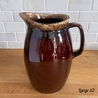 Side view of one 9-inch brown drip glaze ceramic pitcher with handle