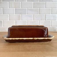 Side view of covered butter dish showing drip glaze rim and glossy finish