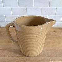 front three-quarter view showing handle, spout and ribbing