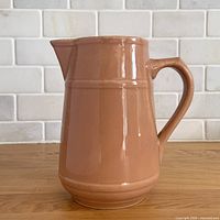 Right side view of mocha glazed banded pitcher with handle and spout