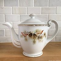 front view of porcelain teapot showing Pine Tree pattern and gold trim