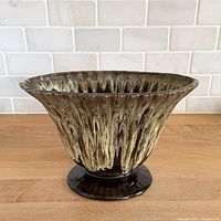 Oblique front view showing yellow drip glaze, ribbing and foot