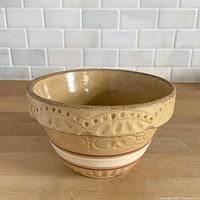 Oblique view of yellow ware mixing bowl showing interior and decorative rim
