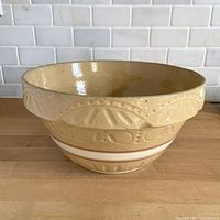 Side view of yellow ware mixing bowl showing embossed pattern and interior glaze