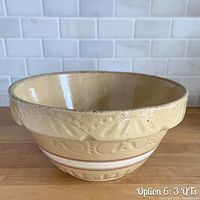Oblique view of yellow ware mixing bowl showing embossed band, stripe decoration and interior glaze